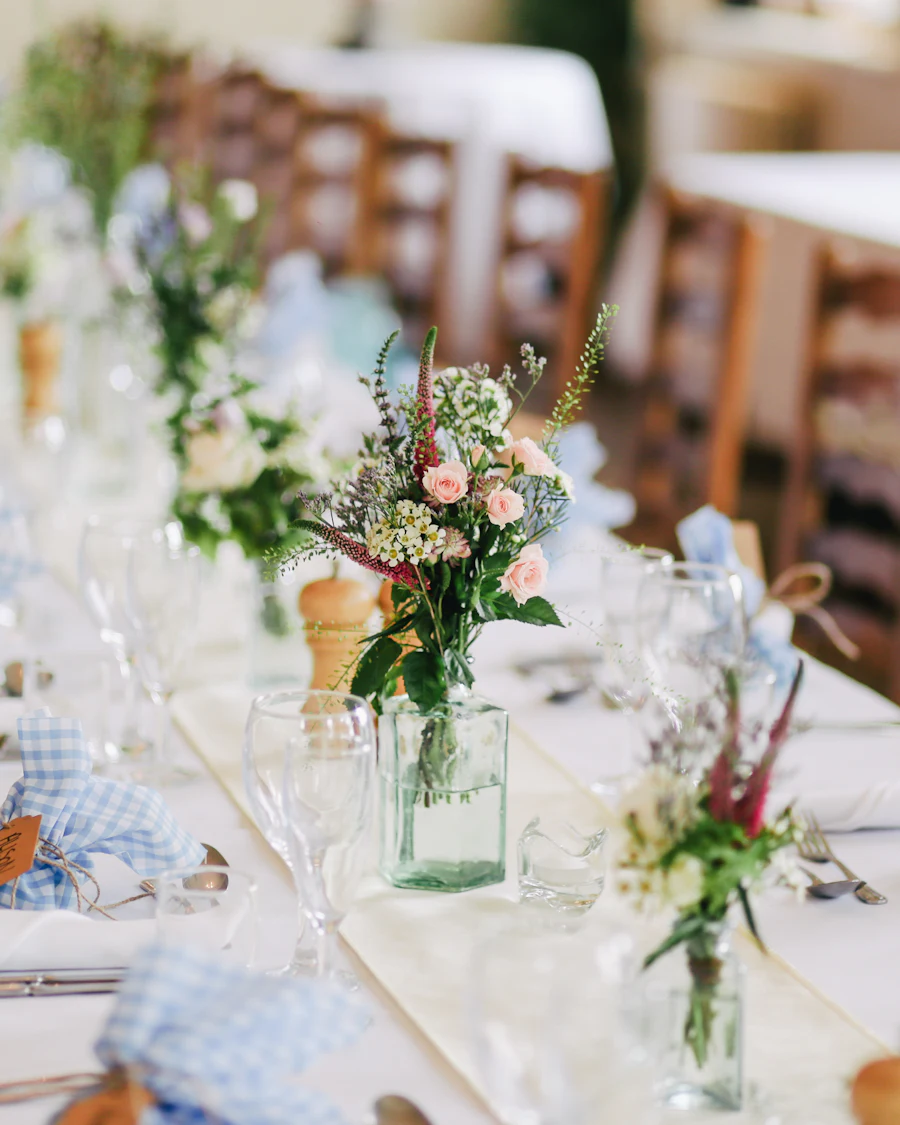 A table centerpiece of pink roses and small white flowers