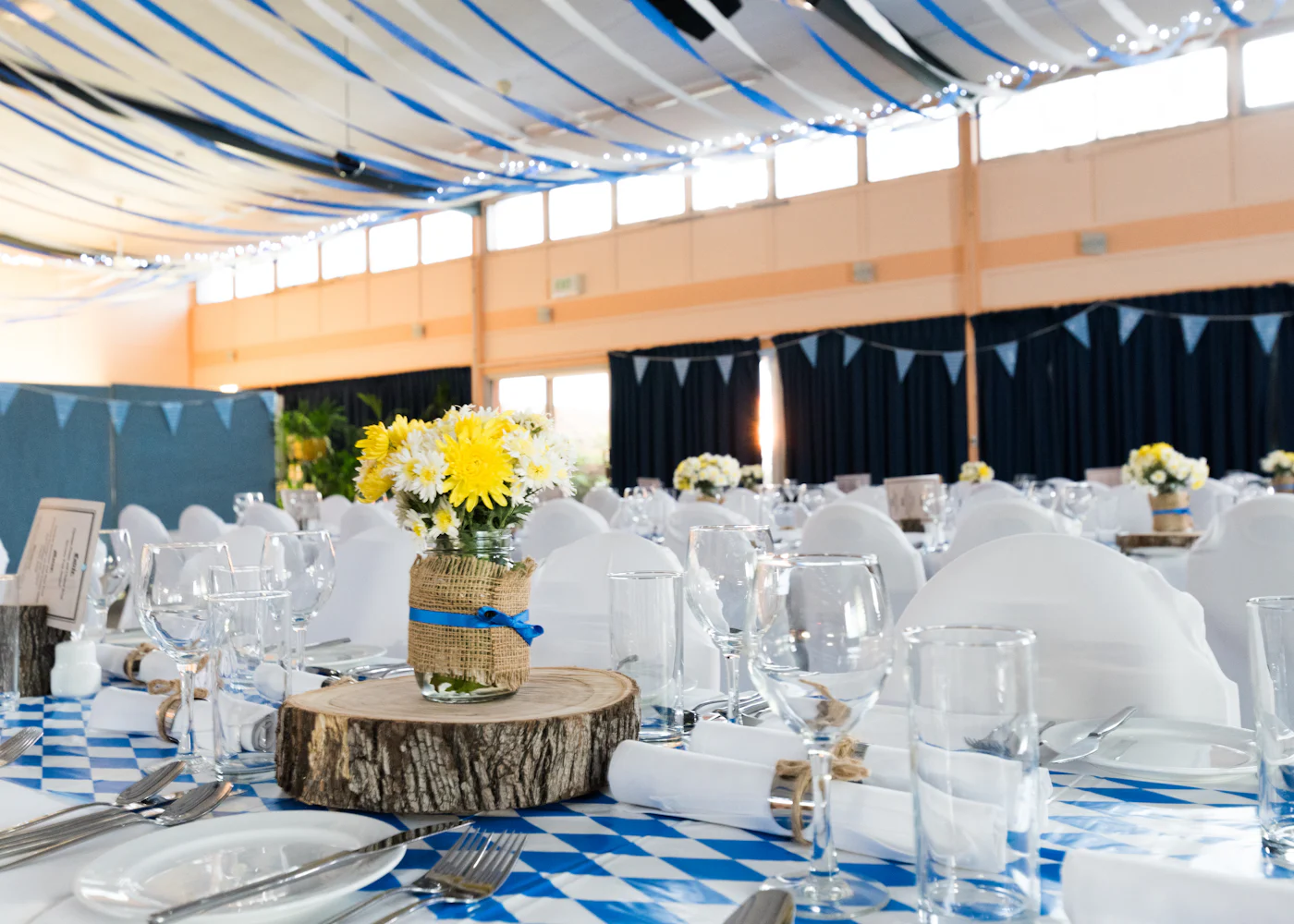 A reception room with small floral centerpieces on the tables
